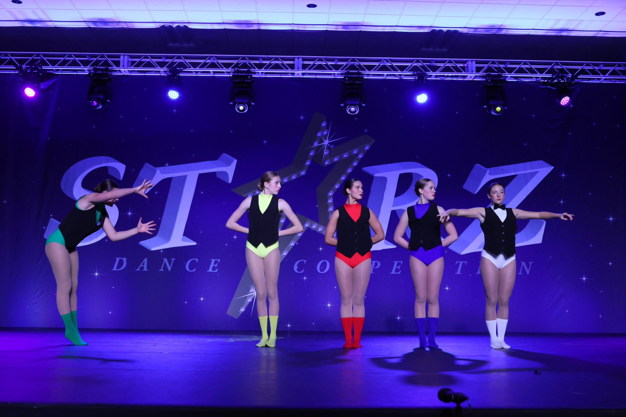 Dancers in colorful costumes perform at a competition